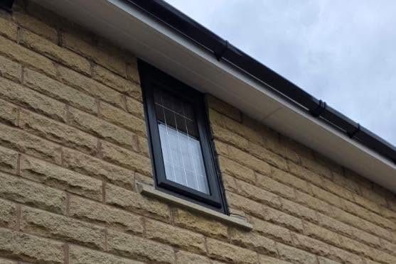New window and guttering on a stone gable